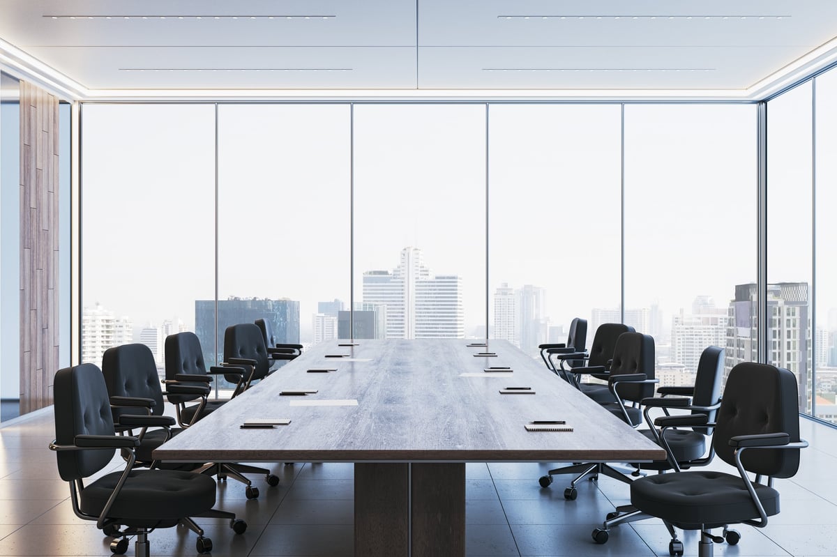 Spacious corporate boardroom with a sleek wooden table and floor-to-ceiling windows
